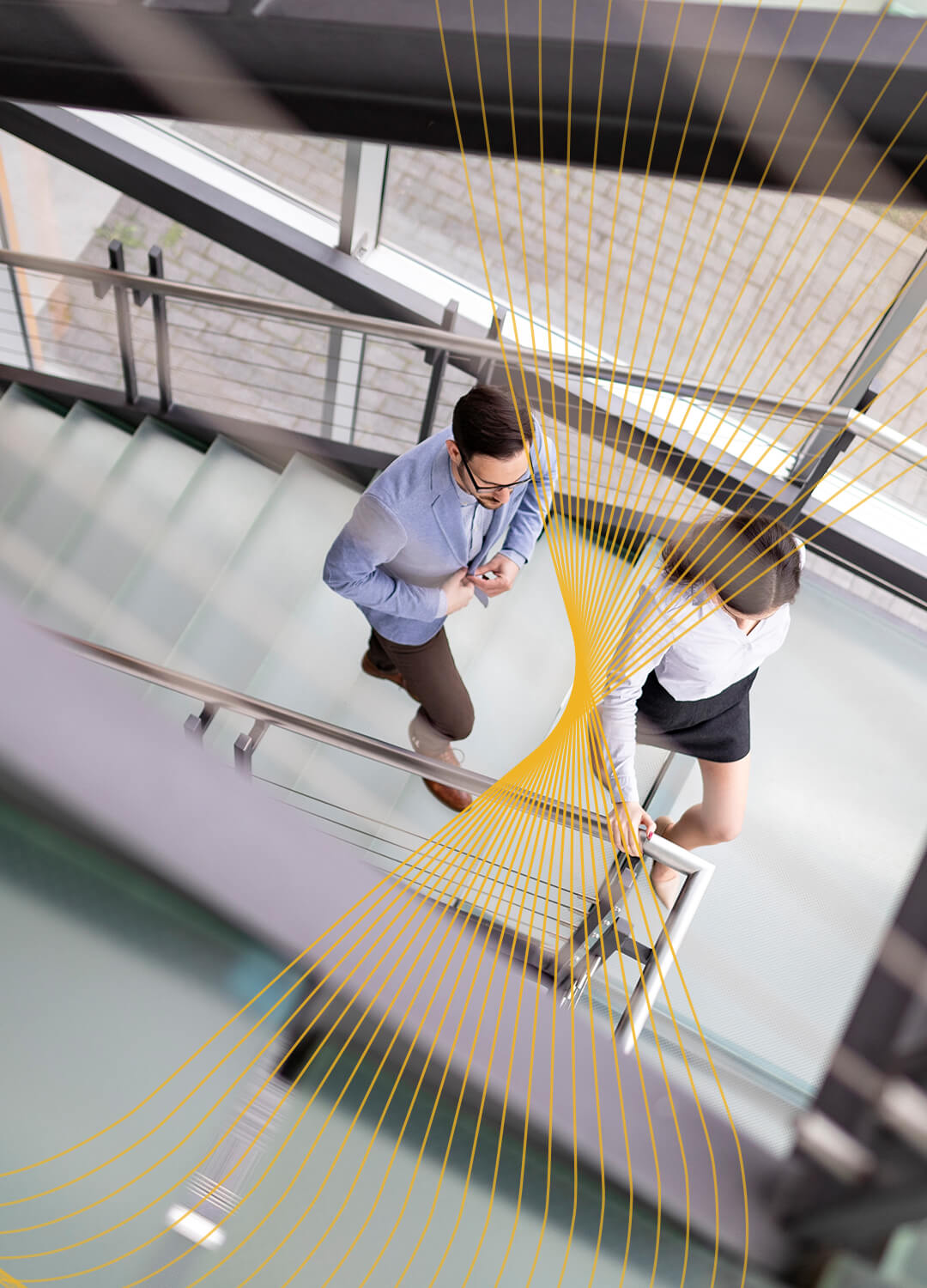 Image of a man and a women walking up stairs in an office